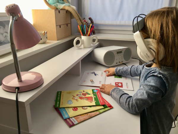 Dziecko słucha przez słuchawki nauszne programu scłuchowego