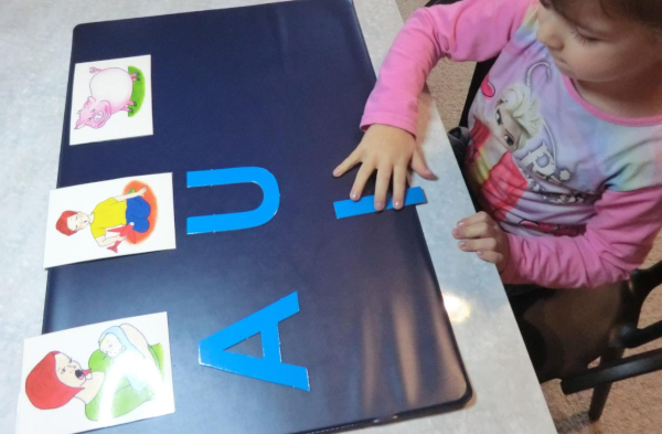 Dziecko dopasowuje samogłoski A, U, i do obrazków